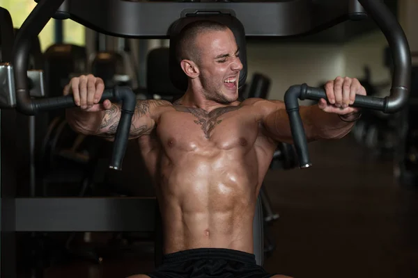 Ung man gör tung vikt övning för bröst — Stockfoto