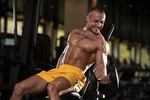 Bodybuilder uitoefening biceps met halters — Stockfoto