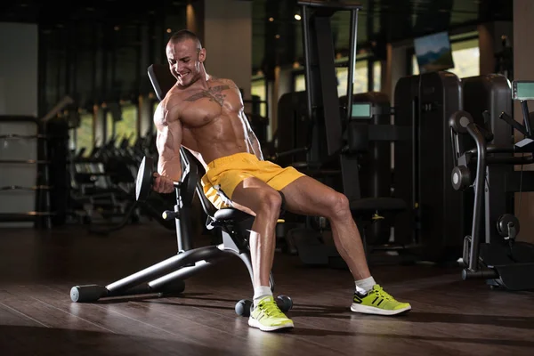 Biceps exercice avec haltères dans une salle de gym — Photo