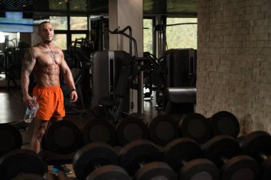 Spor salonu ağırlıkları ile eğitimden sonra yorgun eğitmen