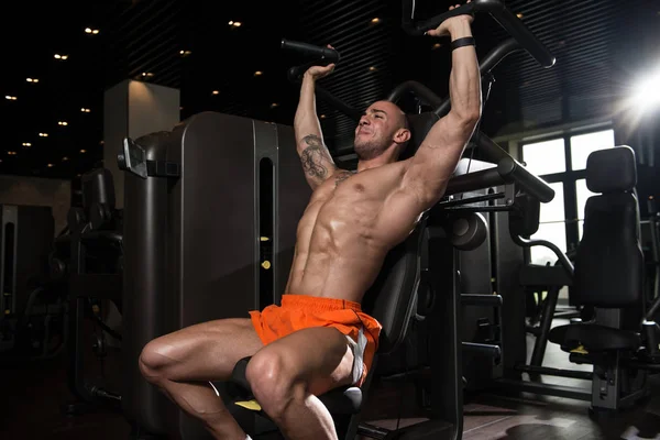 Hombre joven haciendo ejercicio de hombro en el gimnasio —  Fotos de Stock