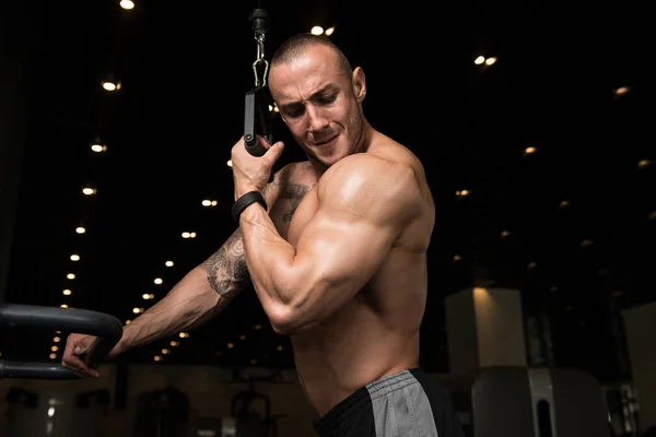 Jeune homme faisant des triceps dans la salle de gym — Photo