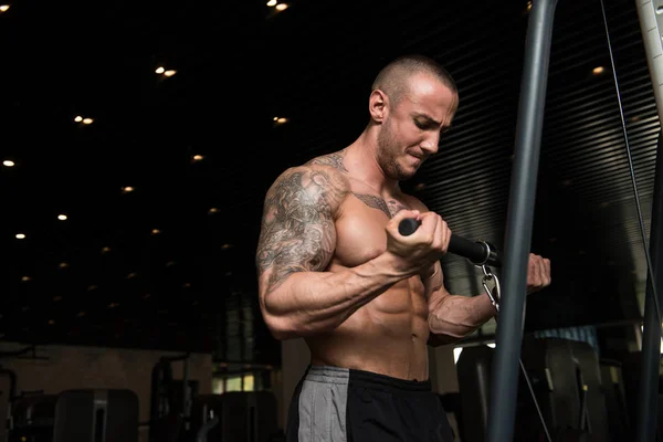 Człowiek robi ćwiczenia na Biceps na kabel maszyny — Zdjęcie stockowe