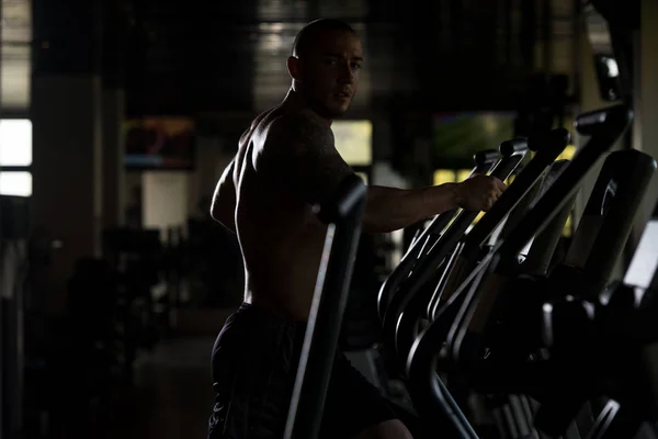 Idrottsman gör Aerobics elliptiska Walker i gymmet — Stockfoto