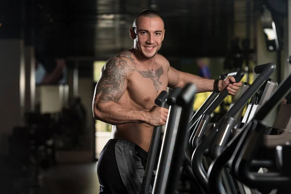 Athlète faisant de l'aérobic elliptique Walker dans le gymnase — Photo