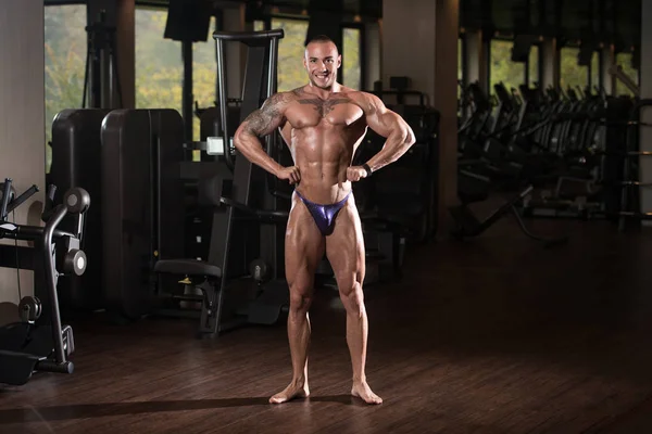 BodyBuilder sérieux debout dans la salle de gym — Photo