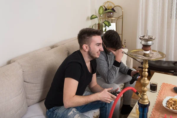 Dos jóvenes guapos jugando videojuegos en la habitación —  Fotos de Stock