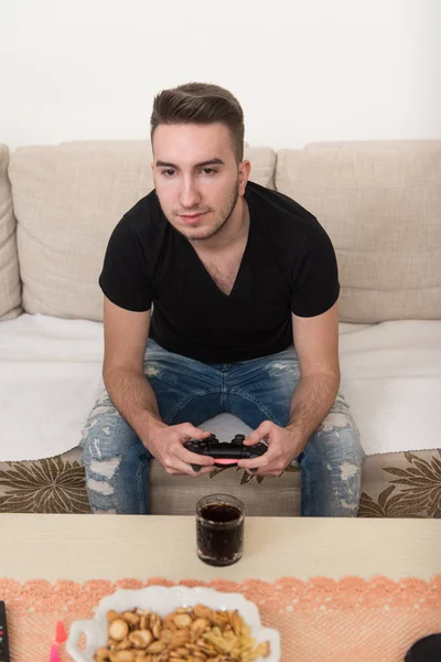 若い男がビデオゲームをしていて — ストック写真