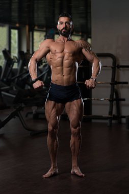 Yakışıklı kaslı adam içinde jimnastik salonu kas esneme