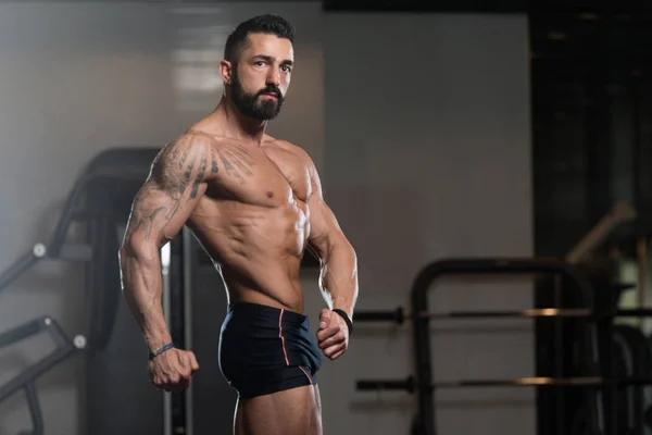 Seriøs kroppsbygger som står i gymmen – stockfoto