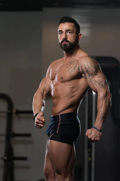 Hombre en el gimnasio mostrando su cuerpo bien entrenado — Foto de Stock