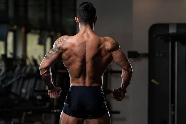 Uomo muscolare Flessione dei muscoli della schiena Posa — Foto Stock