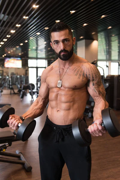 Bodybuilder uitoefening biceps met halters — Stockfoto