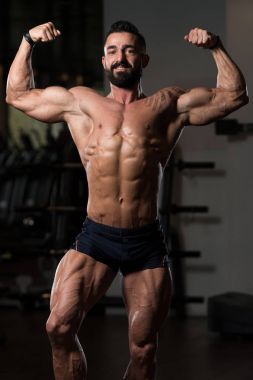 Yakışıklı kaslı adam içinde jimnastik salonu kas esneme