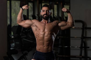 Vücut geliştirmeci Fitness Model çifte kol kası egzersizleri sonra poz