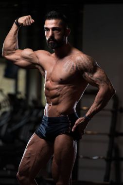 Yakışıklı kaslı adam içinde jimnastik salonu kas esneme
