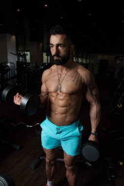 Pazı egzersiz bir spor salonunda Dumbbells ile