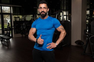 Mavi T-shirt gösteren başparmak yukarıya adam