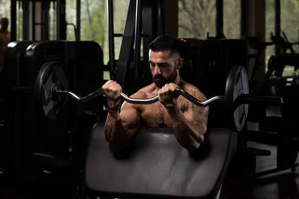 Homme dans la salle de gym faisant de l'exercice Biceps avec Barbell — Photo
