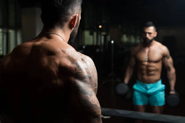 Bodybuilder uitoefening biceps met halters — Stockfoto