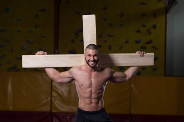 Bodybuilder Dragging a Wooden Cross clipart