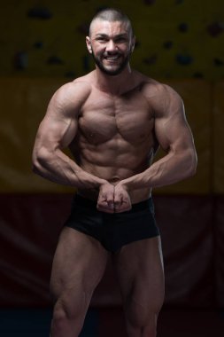 Yakışıklı kaslı adam içinde jimnastik salonu kas esneme