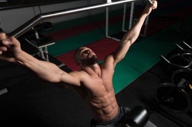 Kaslı adam arka için ağır egzersiz yaparak