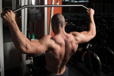 Kaslı adam arka için ağır egzersiz yaparak