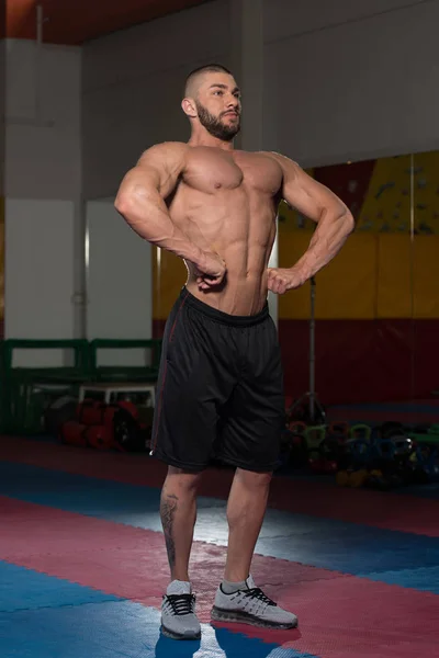 Bodybuilder musculaire montrant sa propagation lat avant — Photo