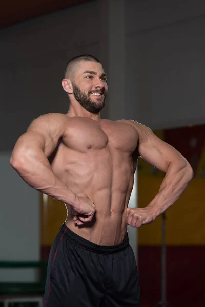 Hombre en el gimnasio mostrando su cuerpo bien entrenado — Foto de Stock