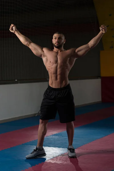 Hombre musculoso guapo flexionando músculos en el gimnasio —  Fotos de Stock