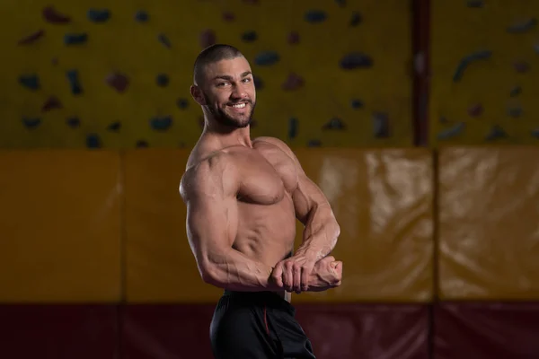 Gespierde bodybuilder tonen van zijn kant borst — Stockfoto