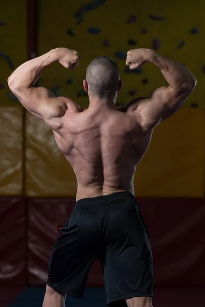 Gespierde bodybuilder tonen zijn terug dubbele biceps — Stockfoto