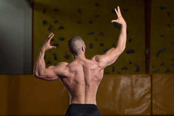 Άνθρωπος στο γυμναστήριο που δείχνει το σώμα του καλά εκπαιδευμένο — Φωτογραφία Αρχείου