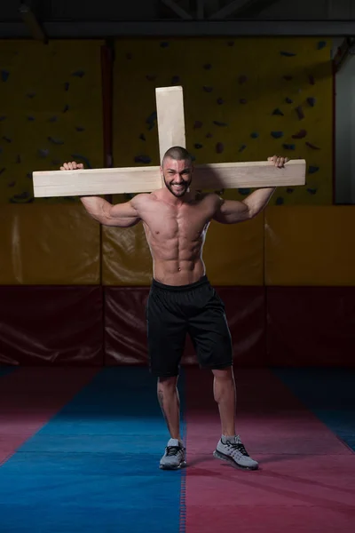 Homme tirant une croix en bois — Photo