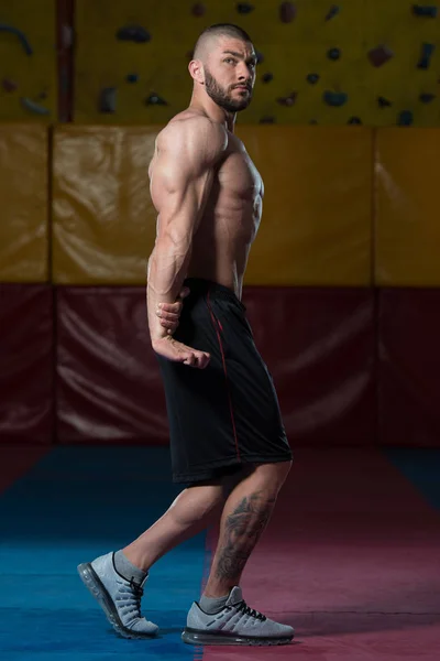 Hombre en el gimnasio mostrando su cuerpo bien entrenado —  Fotos de Stock