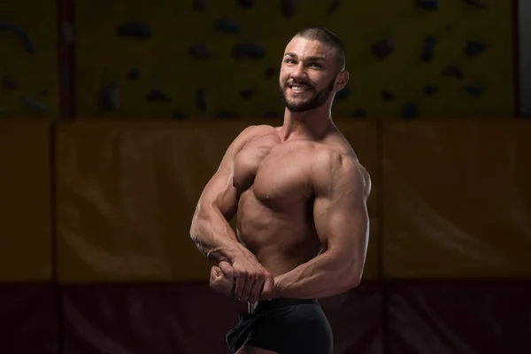 Gespierde bodybuilder tonen van zijn kant borst — Stockfoto