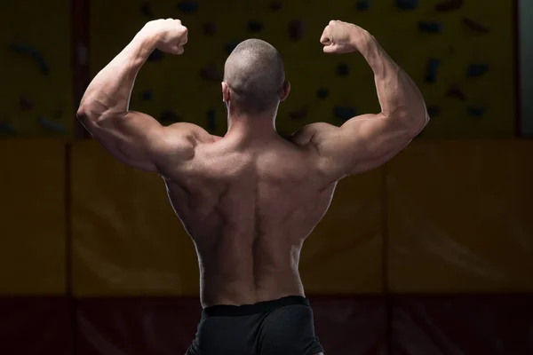 Izmos testépítő mutatja ő vissza dupla bicepsz — Stock Fotó