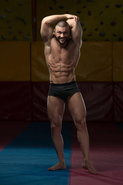 Muscular culturista mostrando sus abdominales delanteros — Foto de Stock