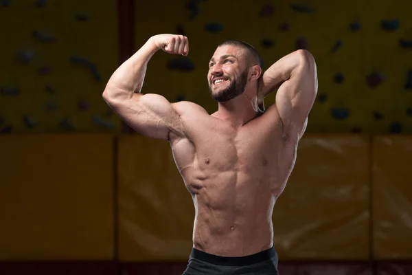 Muskelkräftiger Bodybuilder zeigt seinen Bizeps — Stockfoto