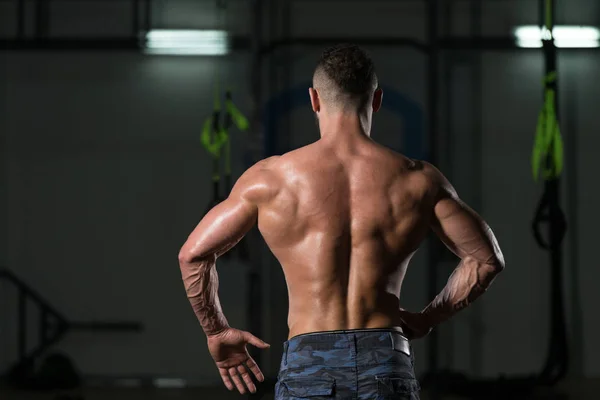 Construtor de corpo muscular mostrando sua volta Lat Spread — Fotografia de Stock