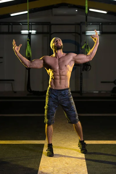 Hombre en el gimnasio mostrando su cuerpo bien entrenado — Foto de Stock