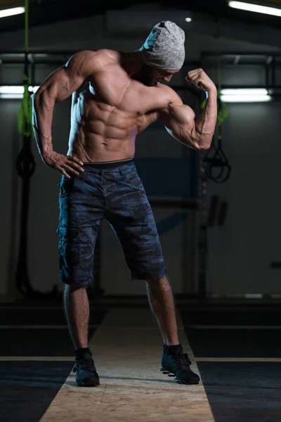 Homme dans la salle de gym montrant son corps bien formé — Photo