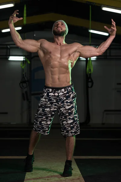 Muscular halterofilista mostrando sua frente duplo bíceps — Fotografia de Stock