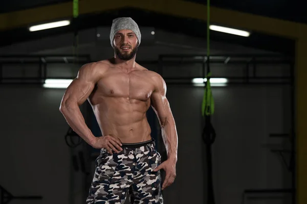 Homem muscular flexionando músculos no ginásio — Fotografia de Stock