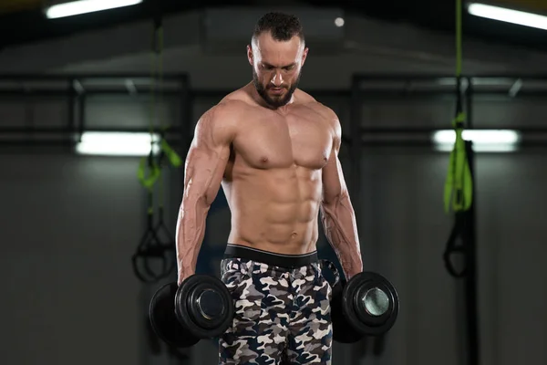 Bodybuilder trainiert Bizeps mit Kurzhanteln — Stockfoto