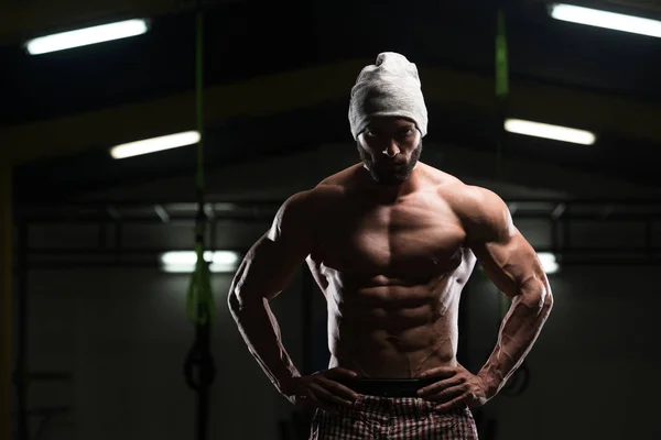 Uomo muscolare che flette i muscoli in palestra — Foto Stock