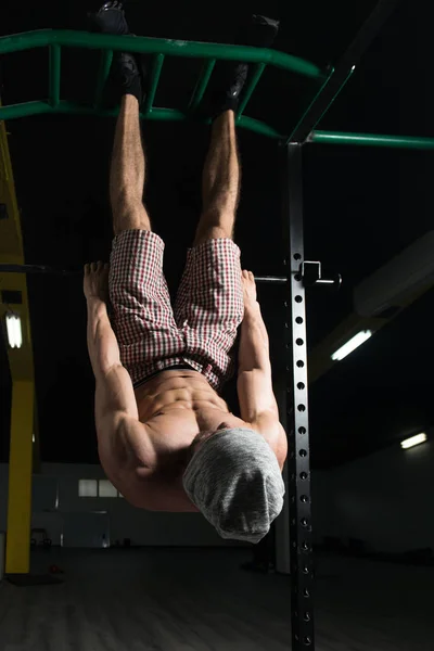 Mann mit hängendem Bein macht Bauchmuskeltraining — Stockfoto