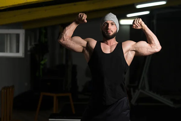 Svalnatý kulturista, ukazující jeho přední dvojitý Biceps — Stock fotografie