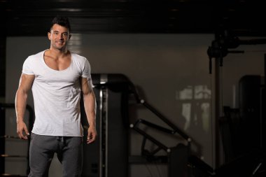 Güçlü adam beyaz tişört arka plan spor salonunda